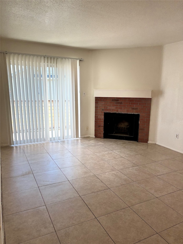 unfurnished living room featuring a fireplace, light tile patterned flooring, and a textured ceiling