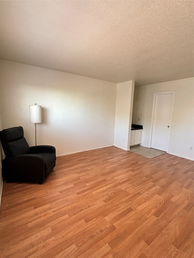 sitting room featuring light hardwood / wood-style floors and a textured ceiling