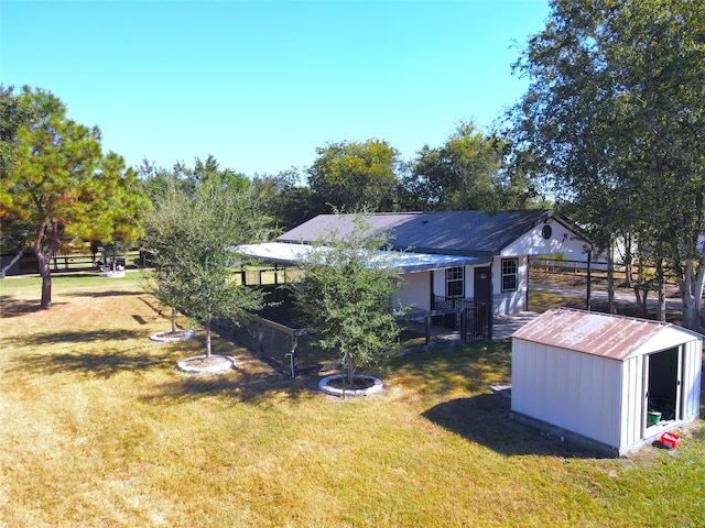 view of yard with a storage unit and an outdoor fire pit