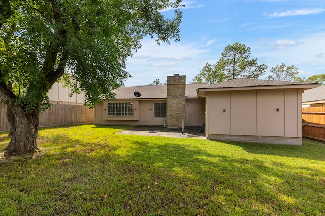 rear view of property with a patio and a lawn