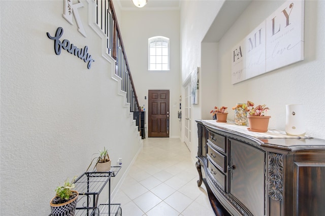 8438 Sunset Isles Dr, Baytown, TX 77521 - entryway featuring light tile patterned floors, stairway, baseboards, and a towering ceiling
