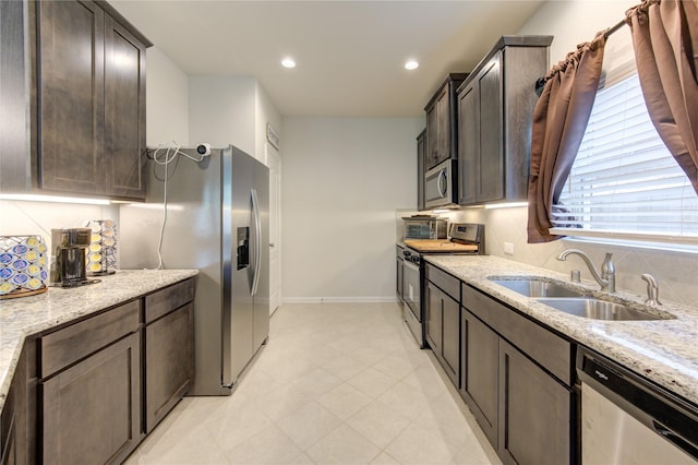 8438 Sunset Isles Dr, Baytown, TX 77521 - kitchen with stainless steel appliances, a sink, baseboards, light stone counters, and backsplash