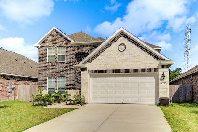 view of property featuring a garage and a front lawn