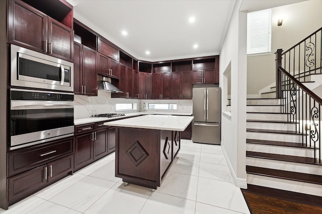 kitchen with tasteful backsplash, light stone counters, a center island, a kitchen breakfast bar, and stainless steel appliances