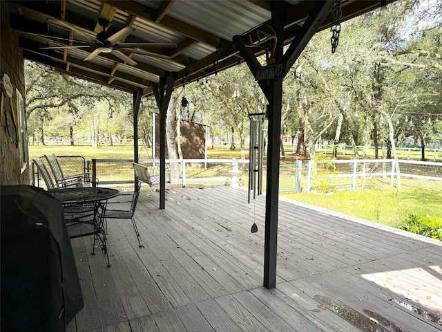 wooden terrace with a lawn, ceiling fan, and area for grilling