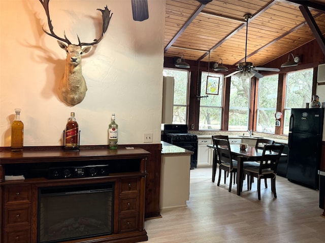 interior space featuring light hardwood / wood-style floors, lofted ceiling, wood ceiling, black appliances, and ceiling fan