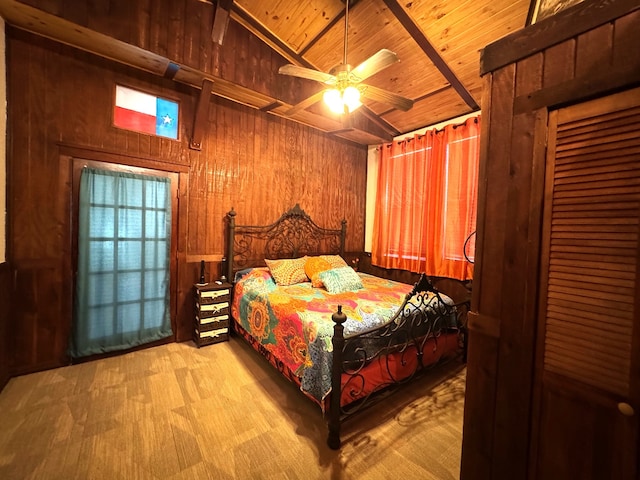 bedroom with vaulted ceiling with beams, light wood-type flooring, wooden walls, wood ceiling, and ceiling fan