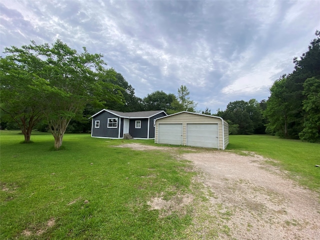 view of front of house with an outbuilding, a front yard, and a garage