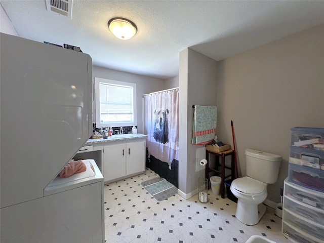 bathroom featuring a shower with curtain, vanity, a textured ceiling, and toilet