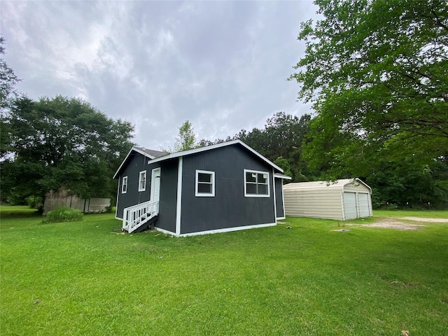 rear view of property with an outbuilding and a yard