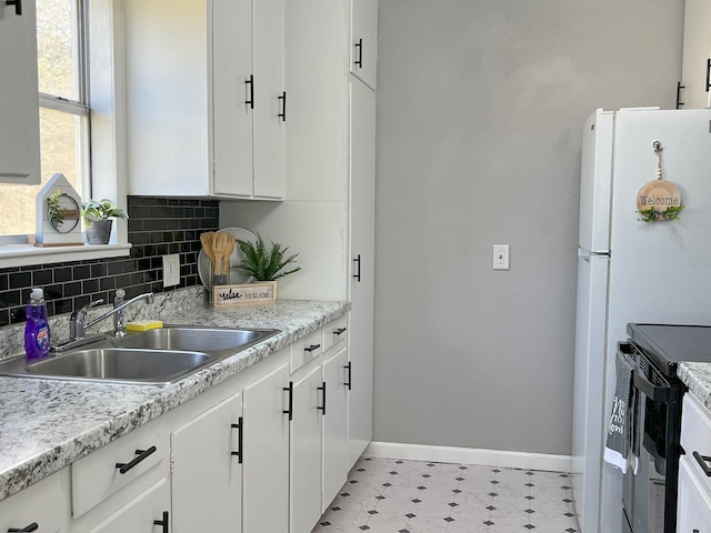 kitchen featuring light countertops, white cabinets, tasteful backsplash, and a sink