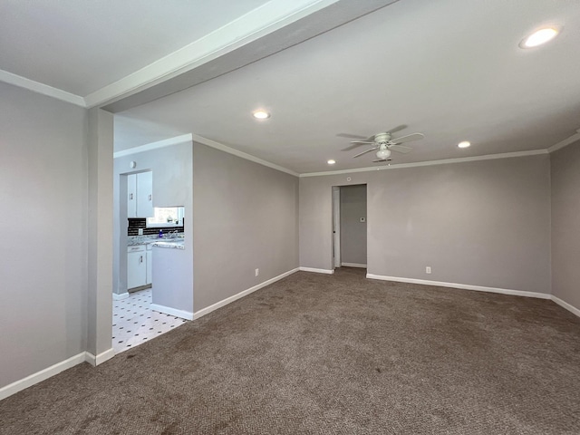 empty room featuring light carpet, crown molding, and baseboards