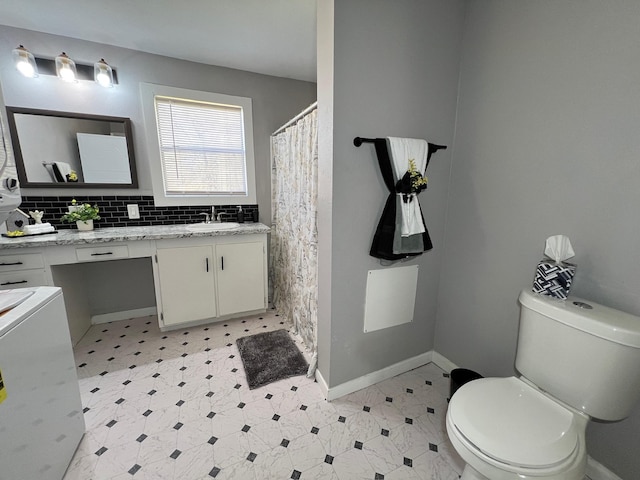 full bath with tile patterned floors, toilet, tasteful backsplash, baseboards, and vanity