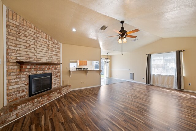 unfurnished living room featuring a fireplace, plenty of natural light, lofted ceiling, and dark hardwood / wood-style floors