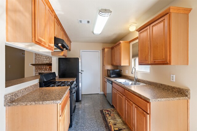 kitchen with black range with gas cooktop, light brown cabinetry, sink, a brick fireplace, and dishwasher