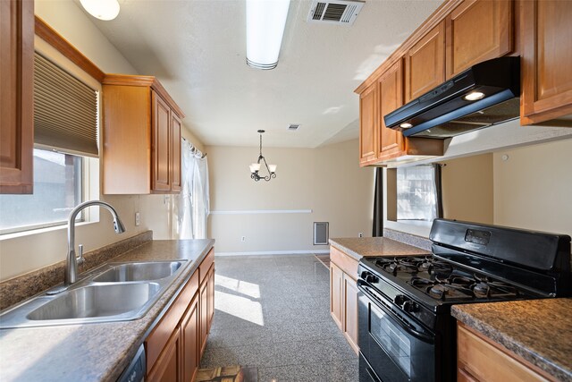 kitchen featuring pendant lighting, sink, gas stove, and an inviting chandelier