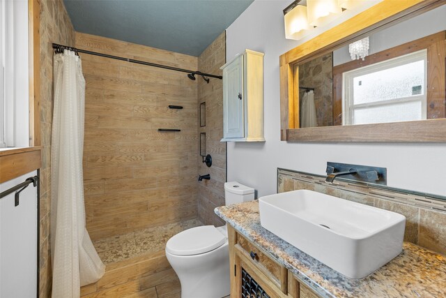 bathroom with hardwood / wood-style floors, curtained shower, vanity, and toilet