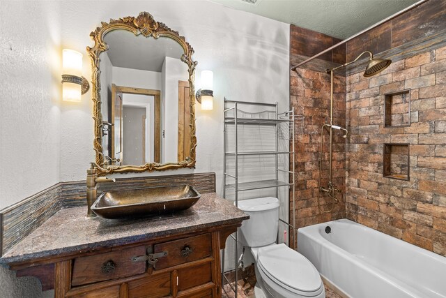 full bathroom with toilet, tiled shower / bath combo, vanity, and a textured ceiling