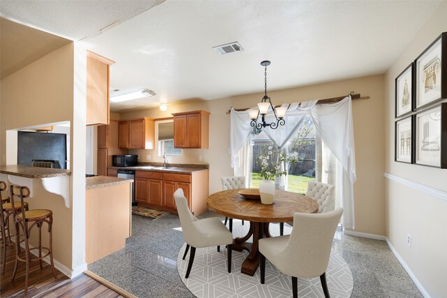 dining space featuring sink and an inviting chandelier