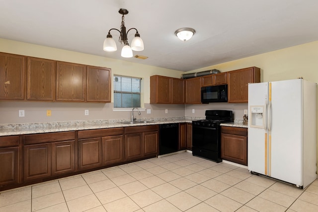 kitchen featuring black appliances, light stone counters, hanging light fixtures, sink, and a chandelier