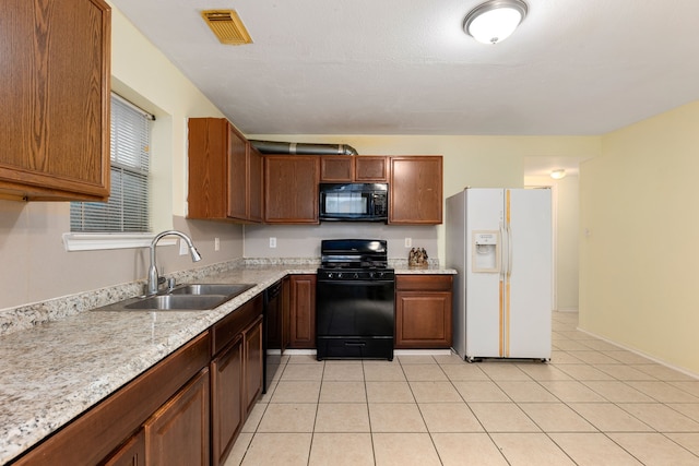 kitchen with black appliances, sink, and light tile patterned flooring