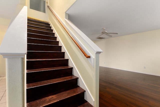 stairs with wood-type flooring and ceiling fan