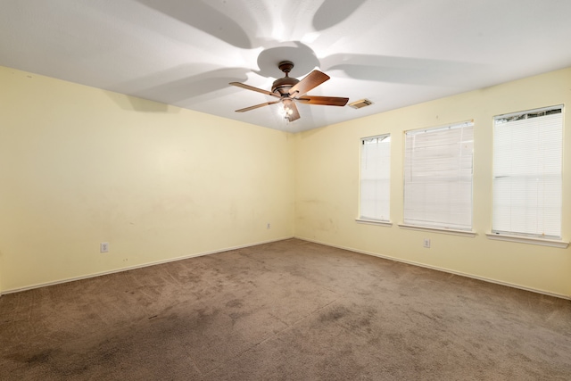 carpeted spare room with ceiling fan