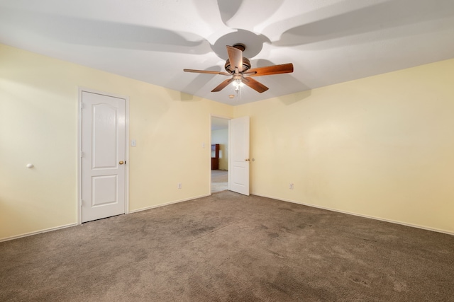 empty room featuring ceiling fan and carpet