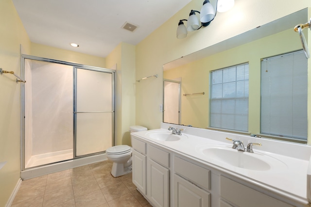 bathroom with tile patterned flooring, vanity, toilet, and a shower with shower door