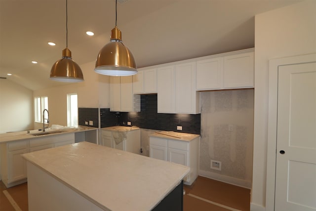 kitchen featuring sink, a center island, and white cabinets