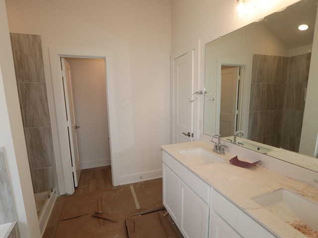 bathroom with vanity, lofted ceiling, and walk in shower