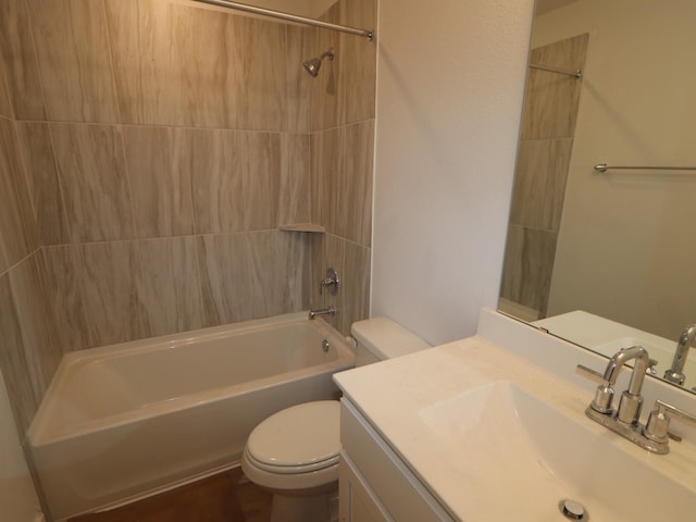 full bathroom featuring vanity, tiled shower / bath combo, and toilet