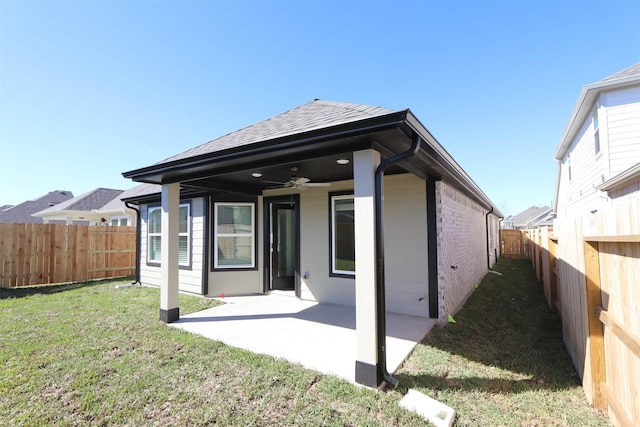 back of house with a ceiling fan, a yard, a fenced backyard, a patio area, and brick siding