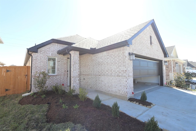 view of front of property featuring concrete driveway, brick siding, a garage, and a shingled roof