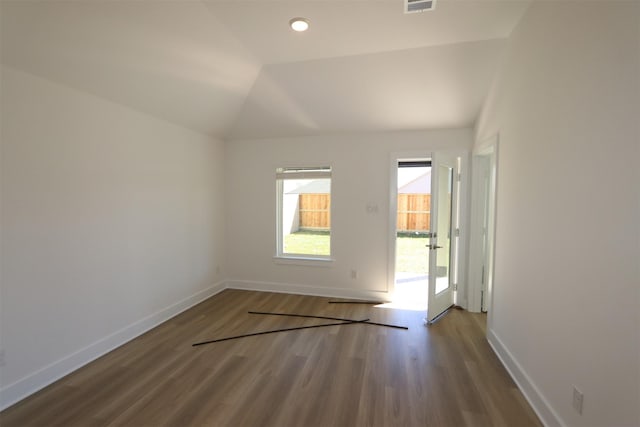 spare room featuring lofted ceiling, wood finished floors, and baseboards