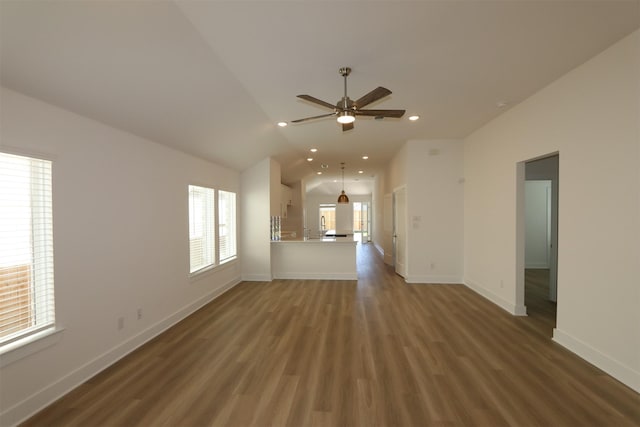 unfurnished living room featuring recessed lighting, wood finished floors, baseboards, and vaulted ceiling