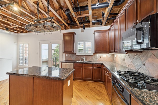 kitchen featuring light hardwood / wood-style flooring, french doors, black appliances, a kitchen island, and sink