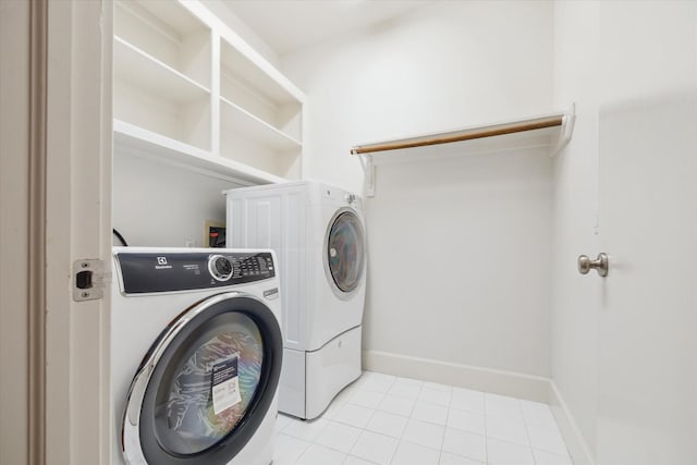 laundry area with washer and clothes dryer and light tile patterned floors