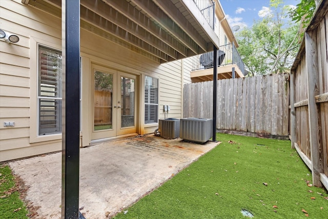 view of yard featuring french doors, a patio area, and central AC unit