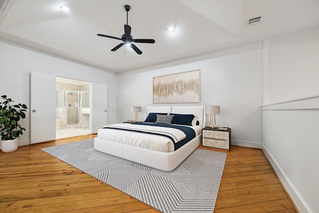 bedroom featuring wood-type flooring, ensuite bath, and ceiling fan