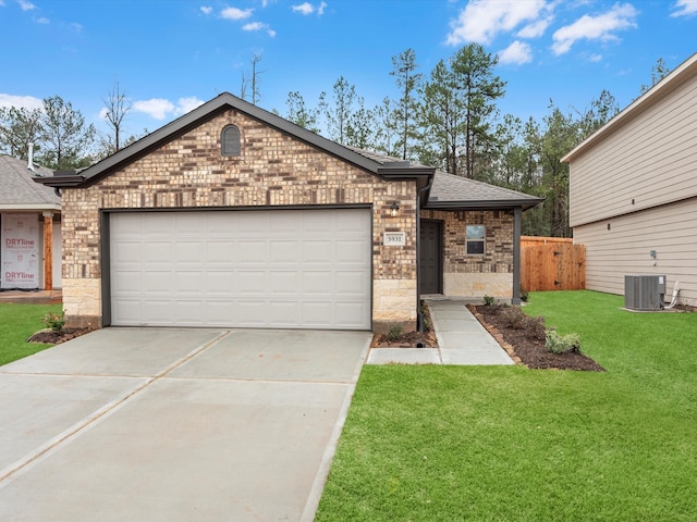 ranch-style home with a garage, central air condition unit, and a front lawn