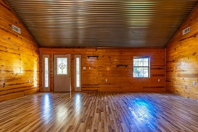 foyer entrance featuring wooden ceiling, wood-type flooring, wooden walls, and lofted ceiling