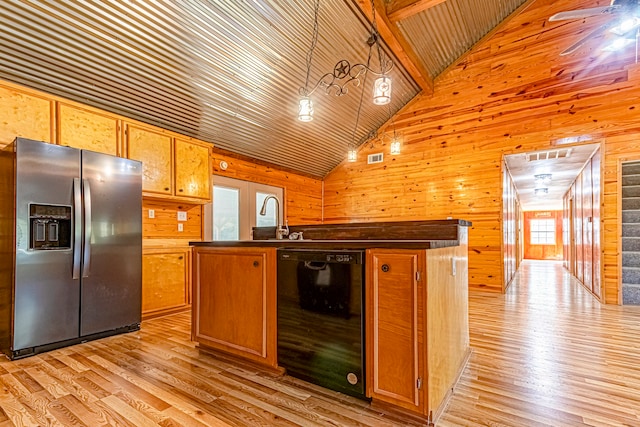 kitchen featuring pendant lighting, wooden walls, dishwasher, and stainless steel fridge