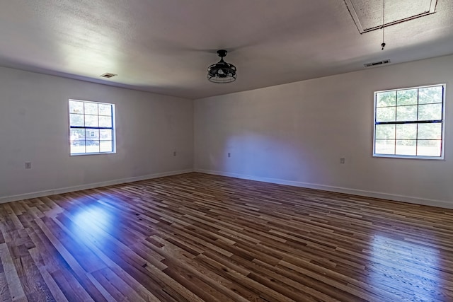 unfurnished room with dark hardwood / wood-style flooring and a textured ceiling