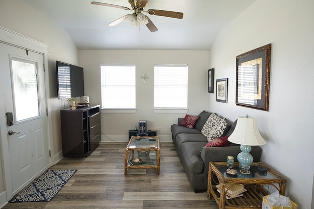 living room with dark wood-type flooring, vaulted ceiling, and ceiling fan