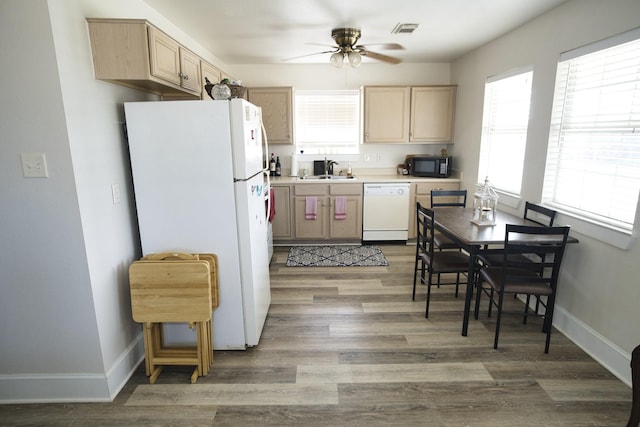 334 Sand Dune Ct, Surfside Beach, TX 77541 - kitchen with white appliances, ceiling fan, light brown cabinetry, wood finished floors, and a sink
