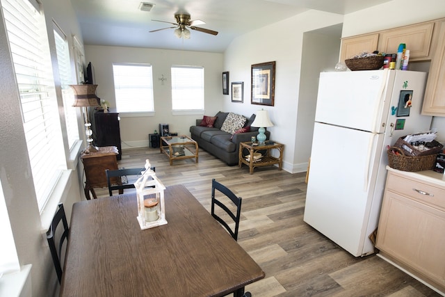 dining space with light hardwood / wood-style flooring, ceiling fan, and vaulted ceiling