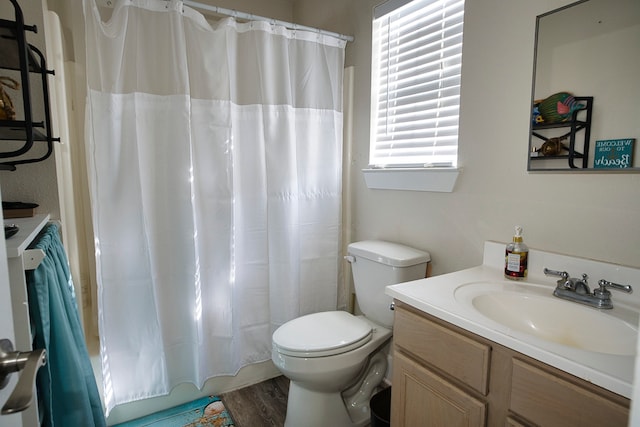 bathroom featuring hardwood / wood-style floors, curtained shower, vanity, and toilet