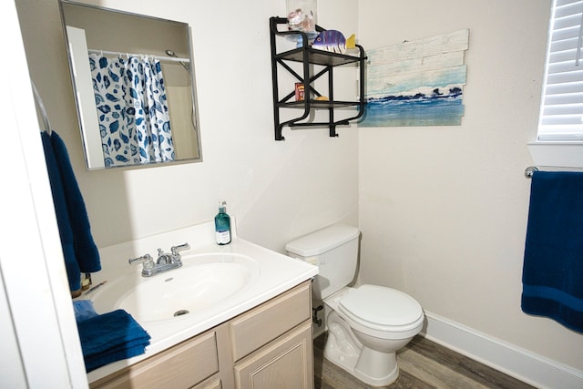 bathroom with hardwood / wood-style floors, vanity, and toilet