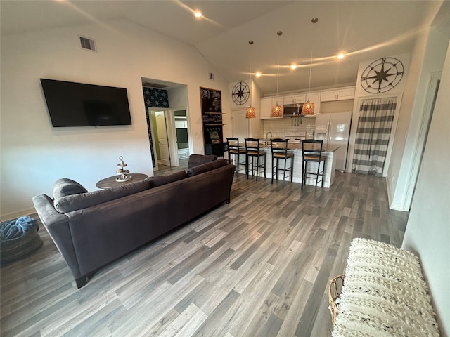 living room featuring high vaulted ceiling and hardwood / wood-style flooring